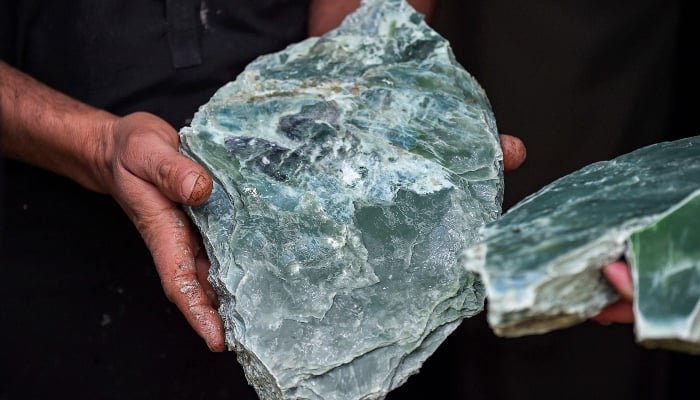 This photograph taken on January 18, 2025 shows an Afghan miner displaying a raw Nephrite rock extracted from a mine in the mountains of Goshta district, Nangarhar province, Afghanistan. — AFP