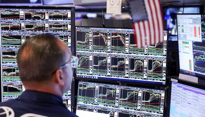 A trader works at the New York Stock Exchange (NYSE) next to a US  flag, after Republican Donald Trump won the US presidential election, in New York City, US on November 6, 2024. — Reuters