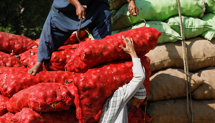 Labourers unload sacks of onion from a truck to supply at a market in Karachi, February 1, 2023. — Reuters