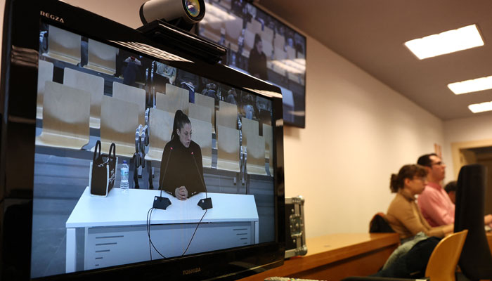 Spanish womens World Cup winner Jenni Hermoso is shown on the television testifying as journalists are pictured in the press room during the trial at the National Court, Madrid, Spain on February 3, 2025. — Reuters