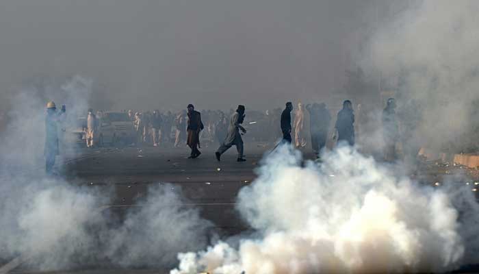 Policemen fire tear gas shells to disperse PTI supporters during a protest in Islamabad, November 26. — AFP