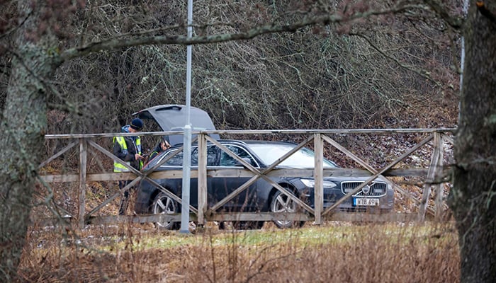 Police officers are pictured behind a vehicle near the Risbergska School in Orebro, Sweden, on February 4, 2025, following reports of a serious violent crime. — AFP