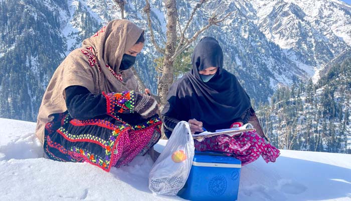 Health workers discuss paper work during a polio vaccination drive in Azad Jammu and Kashmir, February 04, 2025. — AFP