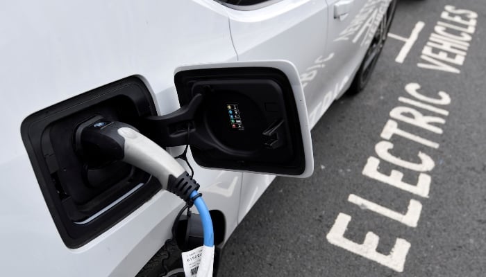 An electric car is charged at a roadside EV charge point, London, October 19, 2021. — Reuters