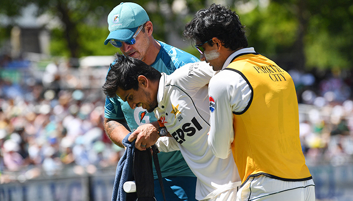 Pakistans Saim Ayub (centre) is assisted off the field after being injured during the first day of the second international Test cricket match between South Africa and Pakistan at Newlands stadium in Cape Town on January 3, 2025. — AFP