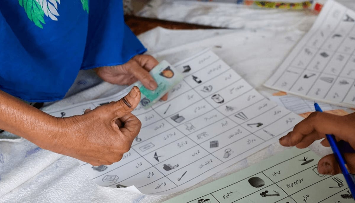 A voter with an ink mark on the thumb goes through paperwork to cast a vote during the general election in Karachi on February 8, 2024. — Reuters