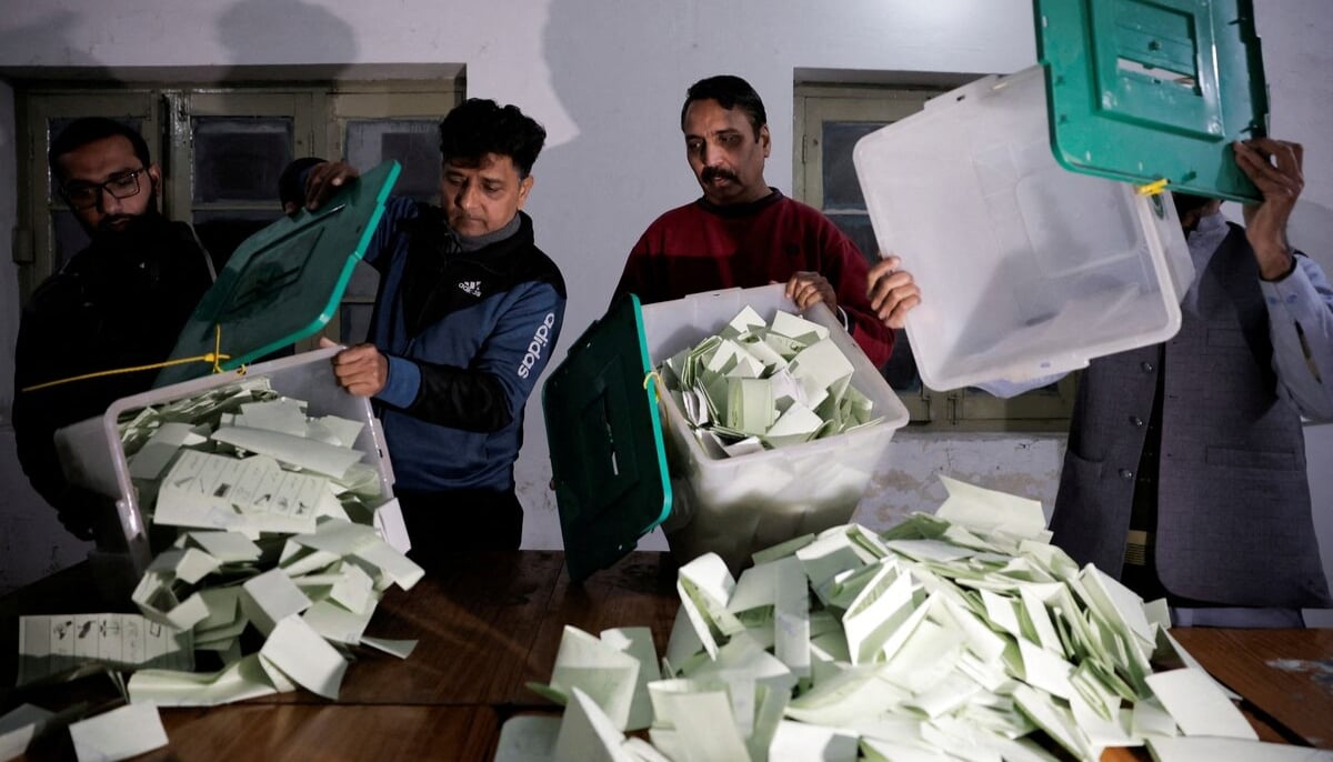 Polling staff empty a ballot box after polls closed at a polling station during the general election, in Lahore on February 8, 2024. — Reuters