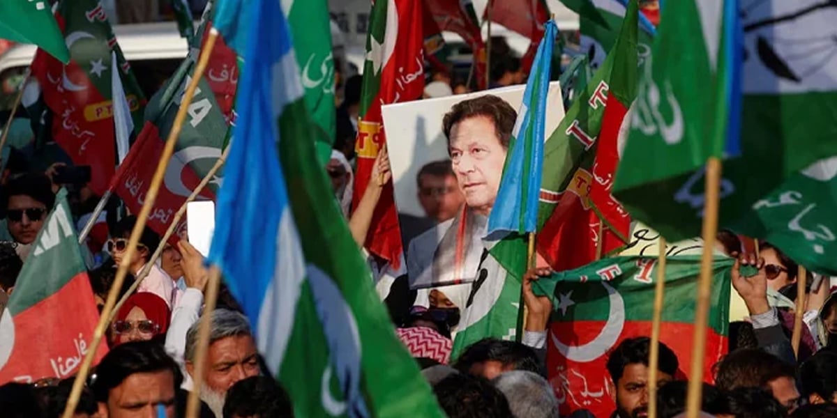 A portrait of the former prime minister Imran Khan is seen amid flags of Pakistan Tehreek-e-Insaf (PTI) and the Jamaat-e-Islami (JI) as supporters attend a joint protest demanding free and fair results of the elections, outside the provincial election commission of Pakistan (ECP)in Karachi on February 10, 2024. — Reuters