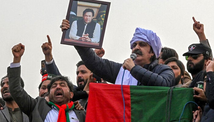 Khyber Pakhtunkhwa Chief Minister Ali Amin Gandapur holds a portrait of former prime minister Imran Khan, during a protest against the alleged skewing in national election results, in Peshawar on February 17, 2024. — AFP