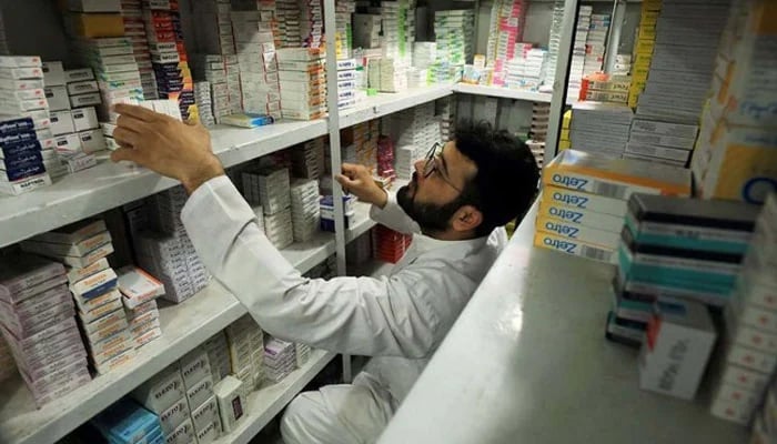 A man sorts and organizes medication packaging in a pharmacy store in Peshawar. - Reuters / File