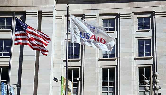 An American flag and USAID flag fly outside the USAID building in Washington, DC, US, February 1, 2025. — Reuters