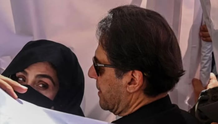 Former prime minister Imran Khan and his wife Bushra Bibi arrive to appear at the high court in Lahore on May 15, 2023. — AFP