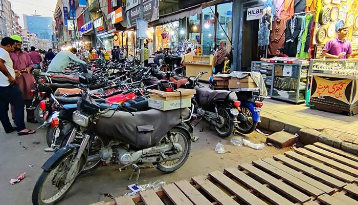 A view of illegal motorbike parking creating hurdles for visitors at Sadar bazaar in Karachi. — INP/File