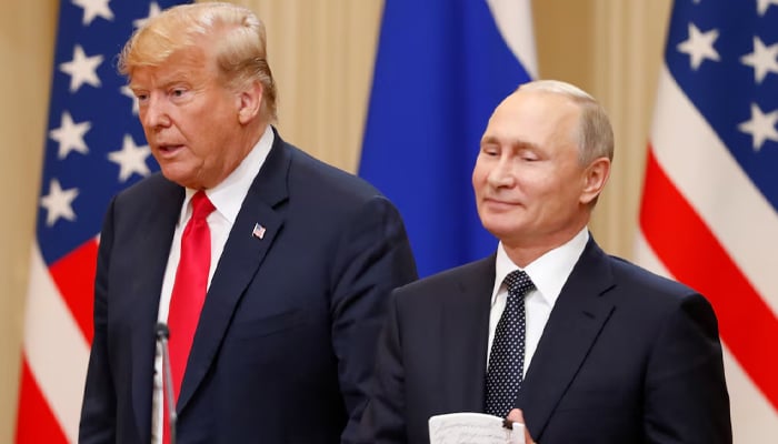 President Trump (L) speaks as Russias President Vladimir Putin stands beside him during a one-on-one meeting in Helsinki on July 16, 2018. — Reuters