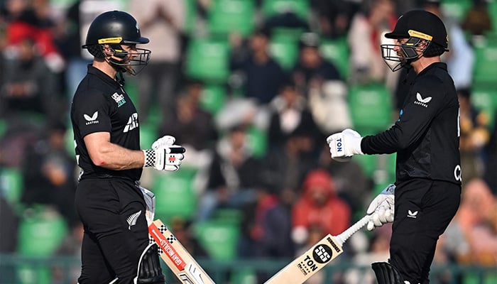 New Zealands Devon Conway (R) bumps fist with teammate Kane Williamson during the Tri-Nation series second ODI cricket match between New Zealand and South Africa at the Gaddafi Stadium in Lahore on February 10, 2025. — AFP