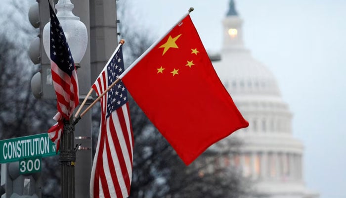 The Peoples Republic of China flag and the US flag fly on a lamp post along Pennsylvania Avenue near the US Capitol in Washington. — Reuters/File