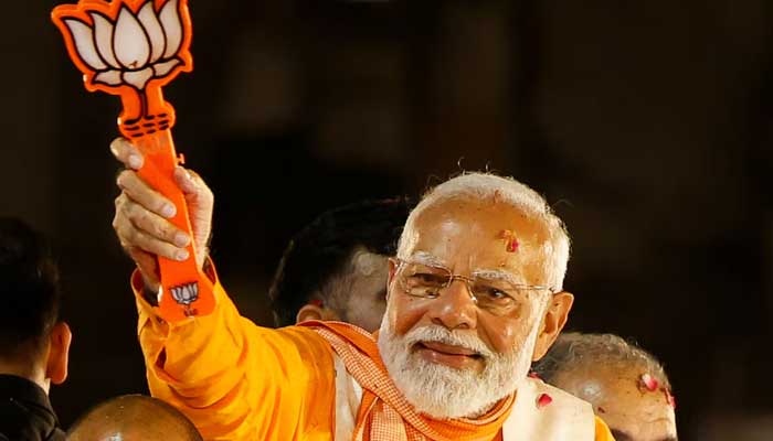 Indias Prime Minister Narendra Modi shows the Bharatiya Janata Party (BJP) symbol during a roadshow as part of an election campaign, in Varanasi, India, May 13, 2024. — Reuters