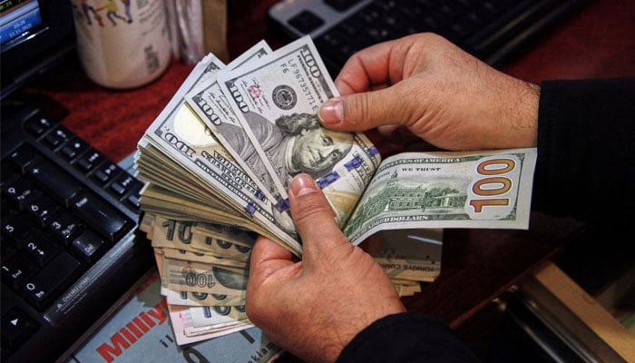 A money changer counts American ticket tickets in a exchange office in Ankara, Türkiye on November 11, 2021. - Reuters