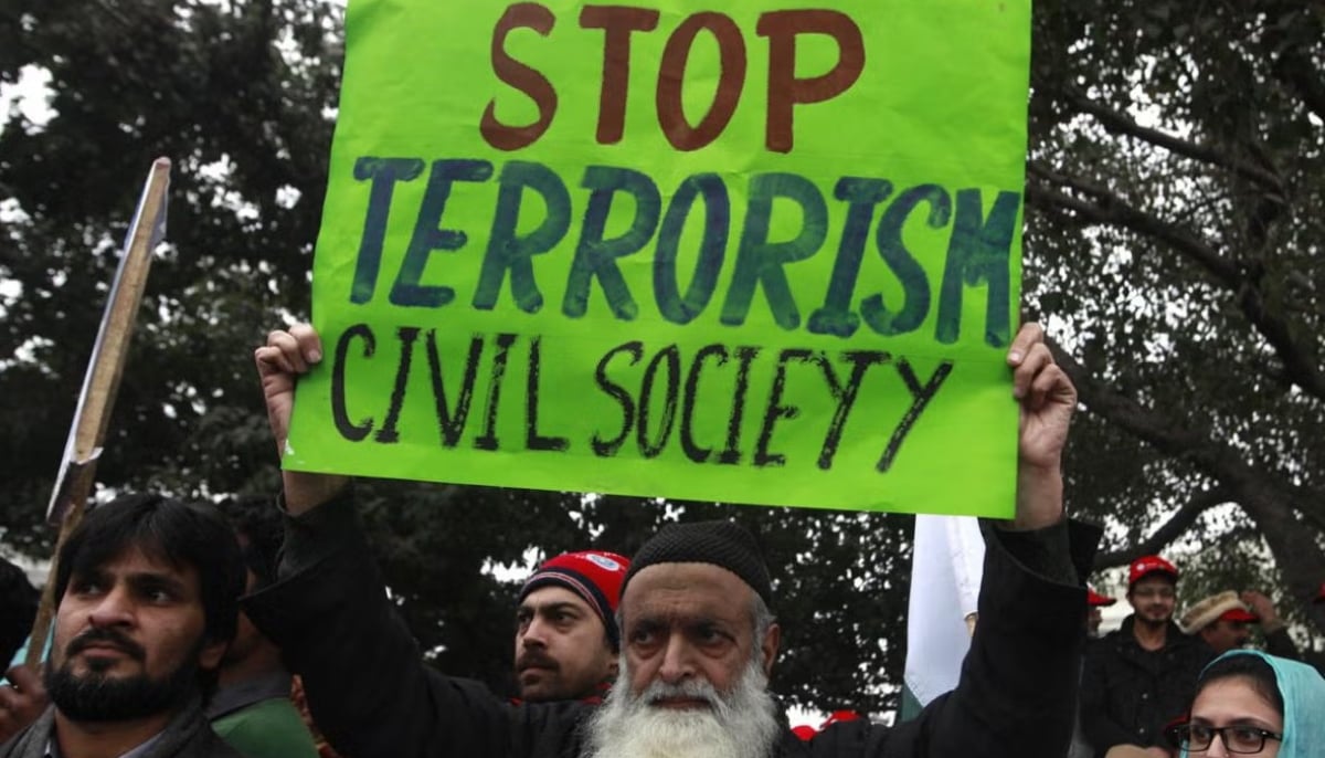 A man holds an anti-terrorism sign along with others during a 2015 peace rally in Lahore. — Reuters/File