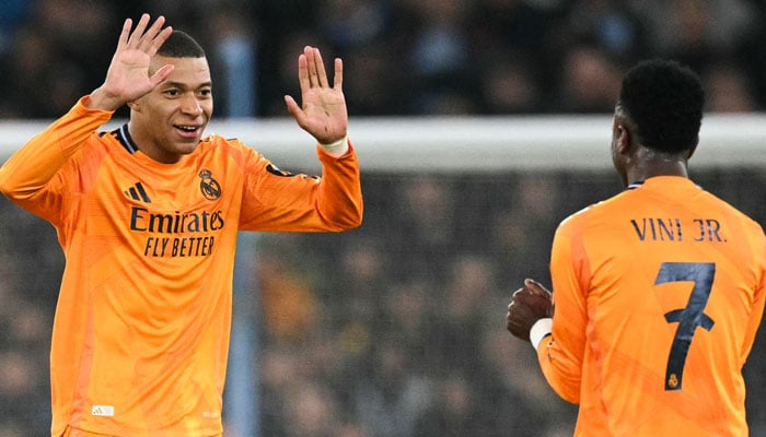 Real Madrid´s French forward #09 Kylian Mbappe celebrates with Real Madrid´s Brazilian forward #07 Vinicius Junior after scoring his team first goal during the UEFA Champions League football match between Manchester City and Real Madrid at the Etihad Stadium in Manchester, north west England, on February 11, 2025. — AFP