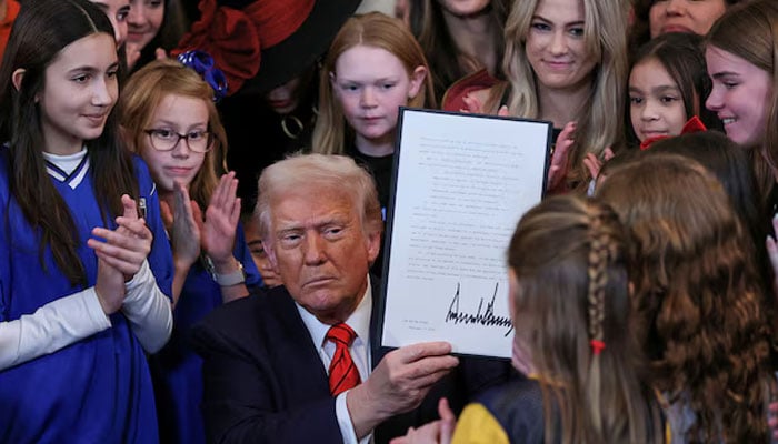 US President Donald Trump holds up a signed executive order banning transgender girls and women from participating in womens sports, in the East Room at the White House in Washington, US, February 5, 2025. — Reuters