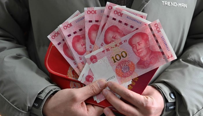 Wang Yanlong shows the 1,500-yuan ($205) he received from the local government after his marriage in early January, at an administrative office in Luliang, northern Chinas Shanxi province on February 11, 2025. — AFP