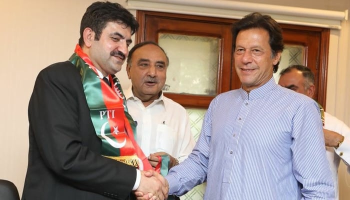 Sher Afzal Marwat (left) shaking the hand of former Prime Minister Imran Khan after joining Pakistan Tehreek-E-insaf. - Facebook/@rayaan.khan.marwat