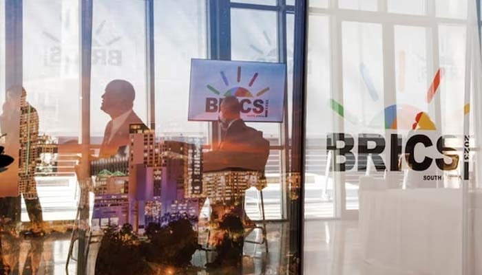 Delegates walk past the logos of the BRICS summit during the 2023 BRICS Summit at the Sandton Convention Centre in Johannesburg, South Africa on August 23, 2023.— Reuters