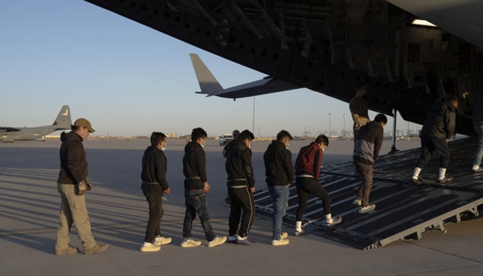 Illegal immigrants being escorted onto a C-17 transport plane in Texas, January 2025. — US Department of Defence