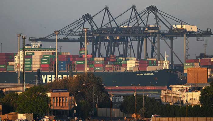 Shipping containers are being stacked on a ship at a seaport in Karachi on April 6, 2023. — AFP