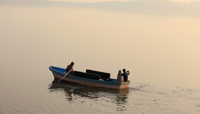 A couple takes a selfie while riding on a boat at the Rawal Lake in Islamabad. — Reuters/File