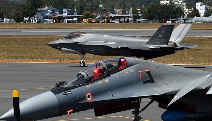 A F-35 fighter jet moves past Indian Air Forces Sukhoi Su-30MKI fighter jet parked on tarmac during the Aero India 2025 air show at Yelahanka air base in Bengaluru, India, February 11, 2025. — Reuters