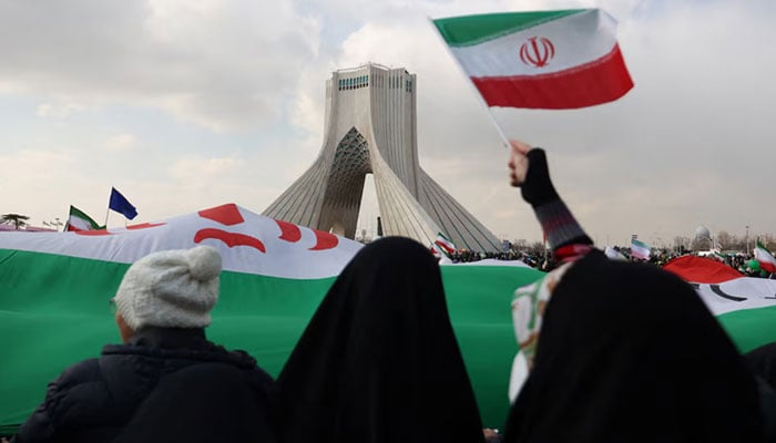 People wave Iranian flags at Azadi Tower in Tehran, Iran. — Reuters/File