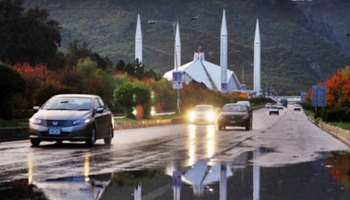 An undated image of cars moving on a road near Faisal Mosque after rain in Islamabad. — APP/File