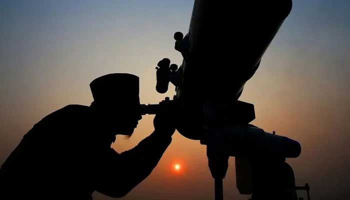 A representational image shows a person using a telescope to sight the moon. — Reuters/File