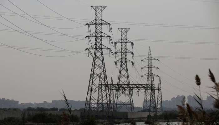 A power transmission tower is seen one day after a power failure across the country in Karachi on January 24, 2023. - Reuters