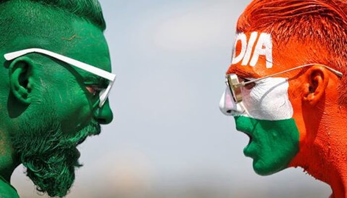 Cricket fans, with their faces painted in the Indian and Pakistani national flag colours, pose for a picture ahead of the first match between India and Pakistan in Twenty20 World Cup super 12 stage in Dubai, in Ahmedabad, India, October 23, 2021. — Reuters