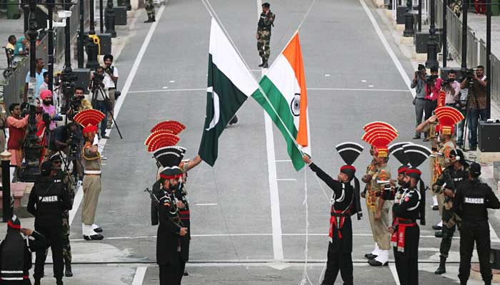 Pakistani Rangers (wearing black uniforms) and Indian Border Security Force (BSF) officers lower their national flags during parade on the Pakistans 72nd Independence Day, at the Pakistan-India joint check-post at Wagah border, near Lahore, Pakistan August 14, 2019. — Reuters