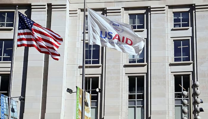 An American flag and USAID flag fly outside the USAID building in Washington, DC, US, February 1, 2025. — Reuters