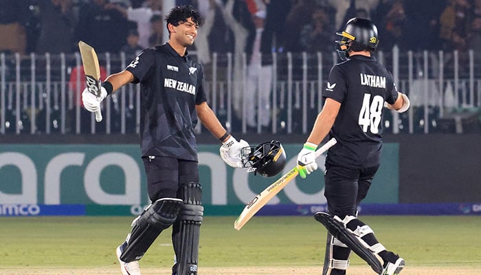 New Zealands Rachin Ravindra celebrates reaching his century with Tom Latham. — Reuters