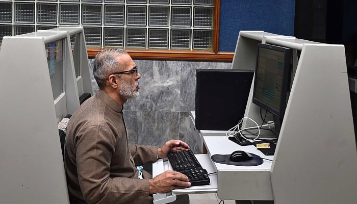 Stockbroker monitors the equity prices during a negotiation session on the Pakistan Stock Exchange (PSX) in Karachi, January 21, 2025. - INP