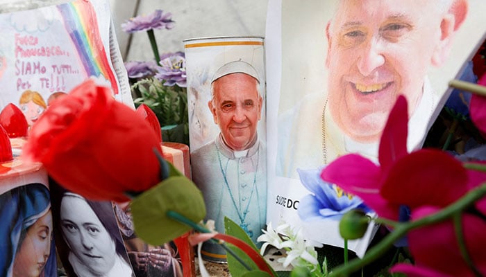 Decorated candles, flowers and pictures of Pope Francis are placed at the base of the statue of the late Pope John Paul II outside Gemelli Hospital, where Pope Francis is admitted for treatment, in Rome, Italy, February 24, 2025. — Reuters