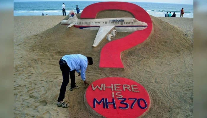 Indian sand artist Sudarsan Pattnaik creates a sand sculpture of the missing Malaysia Airlines flight MH370 on Puri beach in eastern Odisha, India on March 7, 2015. — AFP