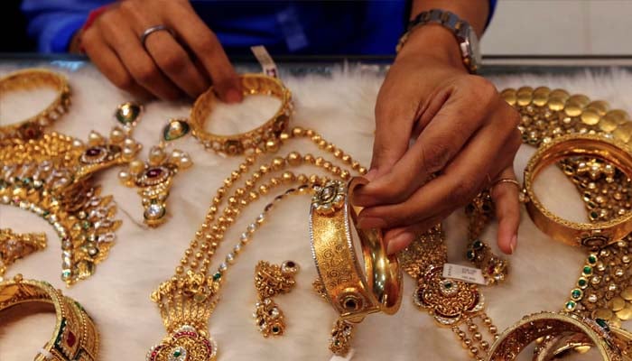 A woman looks at a gold bangle inside a jewellery showroom at a market in Mumbai January 15, 2015. — Reuters