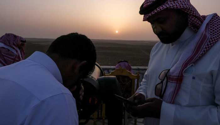 A member of the moon-sighting committee uses a telescope to view the moon ahead of Ramadan, in Tumair, Saudi Arabia, on April 1, 2022. — Reuters