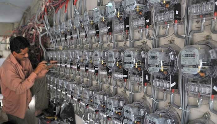 A technician fixes new electricity meters at a residential building in Karachi. — AFP/File