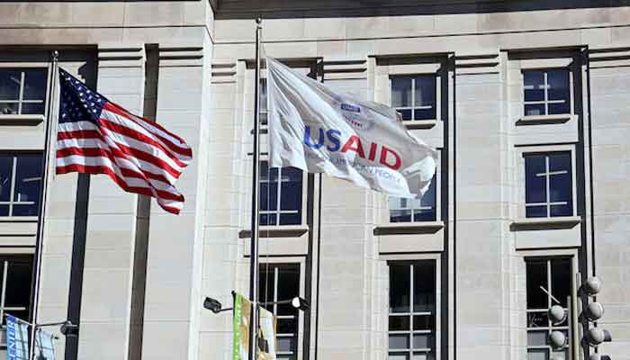 An American flag and USAID flag fly outside the USAID building in Washington, DC, US, February 1, 2025. — Reuters