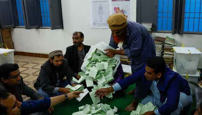 Polling officers count ballot papers during the general election in Karachi, on February 8, 2024. — Reuters