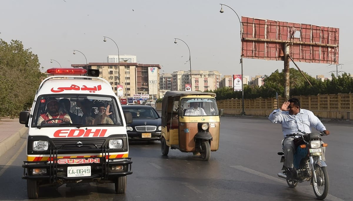 A motorcyclist greets Abdul Sattar Edhi as he commutes to his office in Karachi. — AFP/File