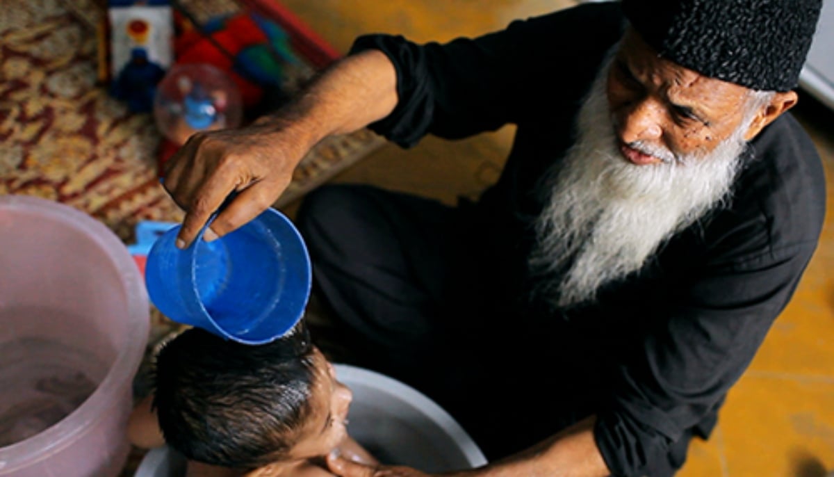 Abdul Sattar Edhi gives a kid at Edhi Foundation a wash. — Edhi Foundation/File